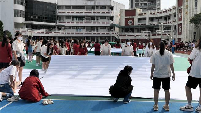 基隆女中24日在操场铺设排字，为明年的百年校庆暖寿，一早，师生们就协力做相关准备，在操场上铺设排字。（翻摄照片／张志康基隆传真）