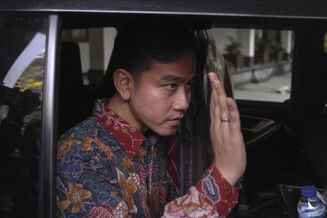 印尼總統佐科威長子吉伯朗現任中爪哇省梭羅市市長，23日露面時向媒體鏡頭揮手致意。（美聯社）