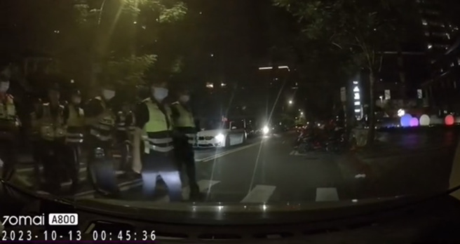 驾驶倒车时疑似未注意后方行人，结果斑马线上一整队警察对他「死亡凝视」，让网友全都笑翻。（图／翻摄自「爆废公社二馆」脸书）