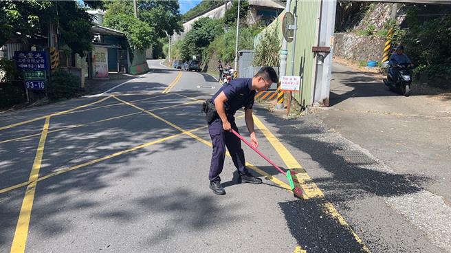 货车载满黑色塑胶碎片不慎掉落，造成路过的7名机车骑士摔车，警方获报到场协助清除。（翻摄画面）