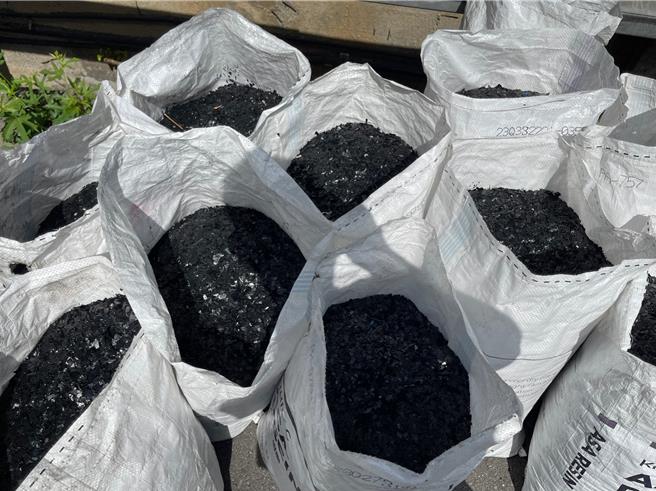 货车载满黑色塑胶碎片不慎掉落，造成路过的7名机车骑士摔车。（翻摄画面）