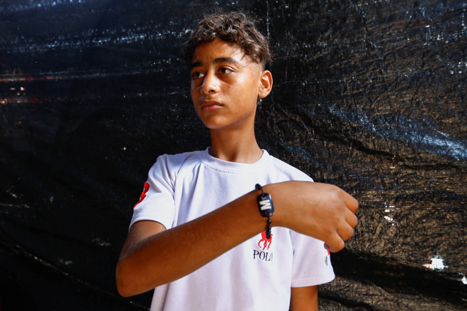 加薩居民阿里埃爾達巴的兒子手腕上繫了特別的手環，當作身份辨識特徵之一。（路透）