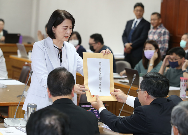 立委王鸿薇（左上）26日在立法院司法及法制委员会中，将立委赵天麟国安疑虑案相关资料，交给国安局副局长徐锡祥（右下）要求调查。（姚志平摄）
