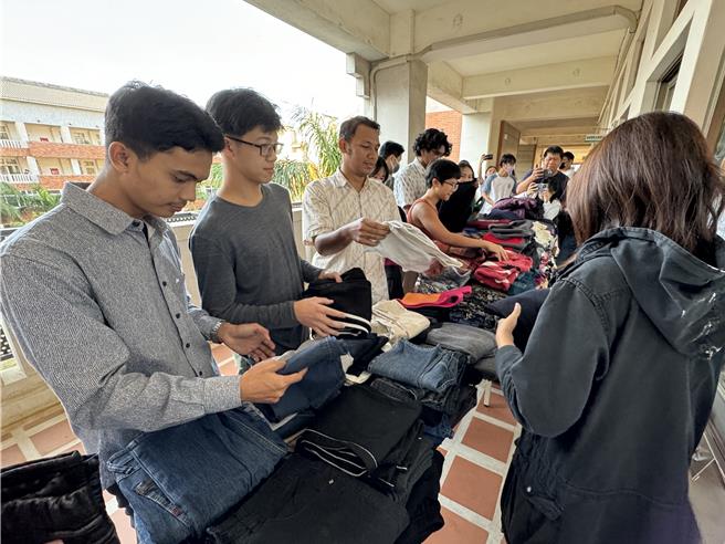 来自东南亚不同国籍的境外学生利用课余时间挑选合适的冬衣，充分感受到各界暖暖的爱心。(于家麒摄)