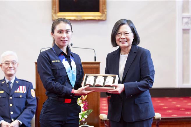 蔡英文總統（右一）26日接見我國世界警消運動會代表團，頒發紀念品給代表團成員，由台北市警局王令樺（中）代表領獎。（警政署提供）
