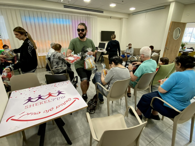 以色列老人日照中心分发零食包礼物 以哈战争导致以色列社福机构面临人手不足问题。（图/中央社）
