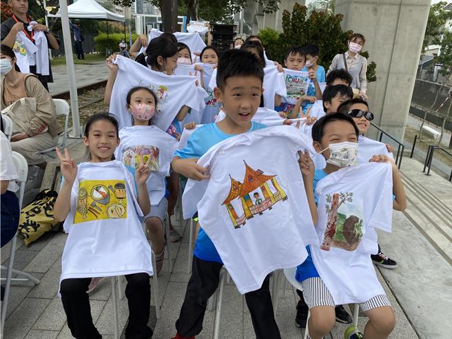 小朋友手拿藝術家設計的「台中衣」參加活動，展現「幸福台中儀式感」精神。（張妍溱攝）