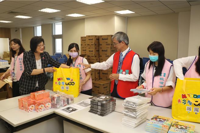 社会局长李美珍（左1）和板信银行副总经理张奇勋（中）一起帮忙分装打包。（新北市社会局提供）