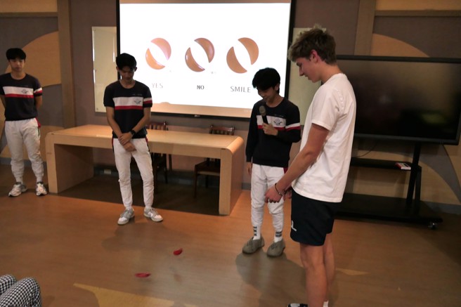 治平高中學生介紹臺灣傳統廟宇，讓英國Marlborough College學生體驗擲筊活動。(醒吾科大提供)

