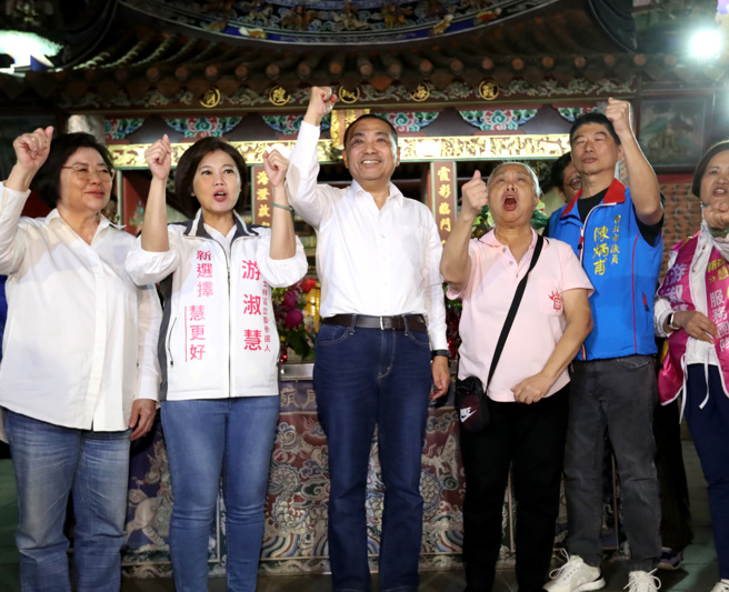 國民黨總統參選人侯友宜（中）27日赴台北市霞海城隍廟參拜，在當地熱情民眾的簇擁下同聲高喊凍蒜。 （鄭任南攝）