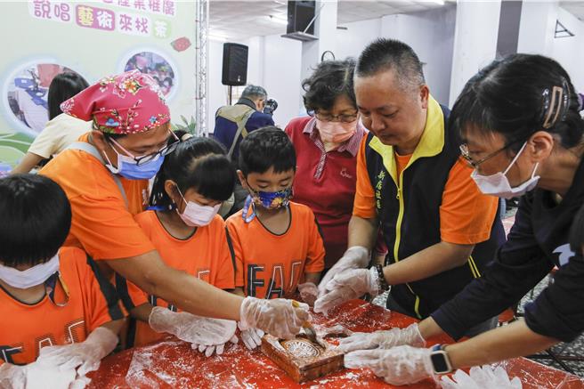 獅潭鄉新店社區27日在義民廟舉辦打新丁粄活動，社區志工與理事長郭寬權（右二）一起教導小朋友製作新丁粄。（黃子明攝）