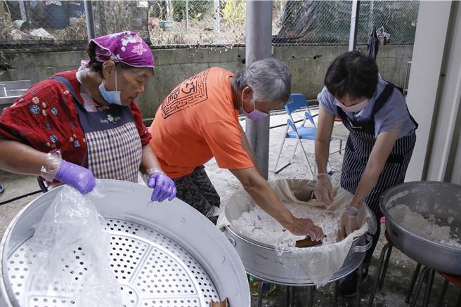 獅潭鄉新店社區27日在義民廟舉辦打新丁粄活動，社區志工正在分裝原料準備蒸煮。（黃子明攝）