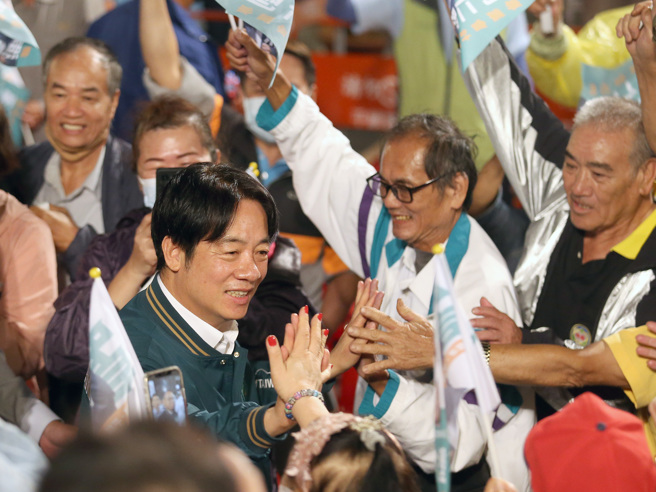 民进党总统参选人赖清德（左）27日出席桃园市立委第五选区刘仁照竞选总部成立大会，支持民眾争相上前击掌致意。（范扬光摄）