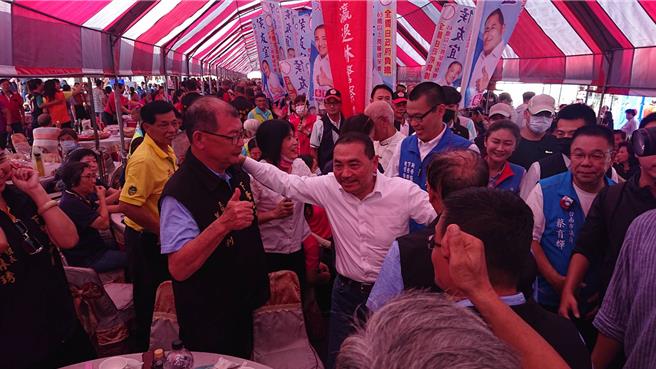 台南市新营太子宫28日中午举办平安宴，国民党总统参选人侯友宜（白衬衫者）逐桌拜票。（程炳璋摄）