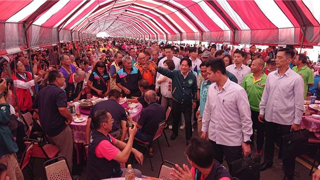 民进党总统参选人赖清德（中间绿夹克）28日中午参加新营太子宫平安宴，向用餐民眾挥手。（程炳璋摄）