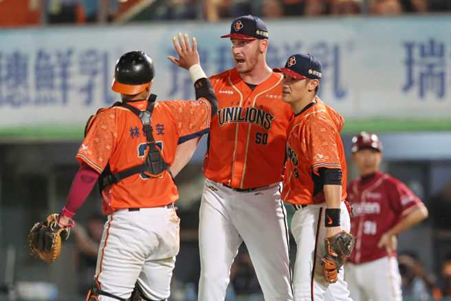 统一狮一垒手陈镛基（右）美技接杀并完成双杀守备，先发投手布雷克（中）也上前为他鼓励。（统一狮提供）