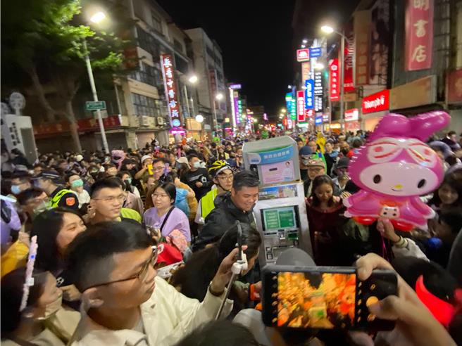 新竹市政府28日晚間舉辦萬聖節變妝大遊行，「新政治提款機」人裝道具今晚7點準時出現在影像博物館，但過程中被臉譜人團團圍住，所幸在多位議員協助下才得以移動。（陳育賢）