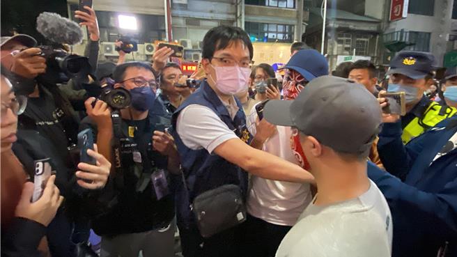 「新政治提款機」人裝道具今晚7點參加萬聖大遊行時準時，多名臉譜人圍在一旁，其中1人還不時抽菸，最後被警方帶回盤查。（陳育賢）