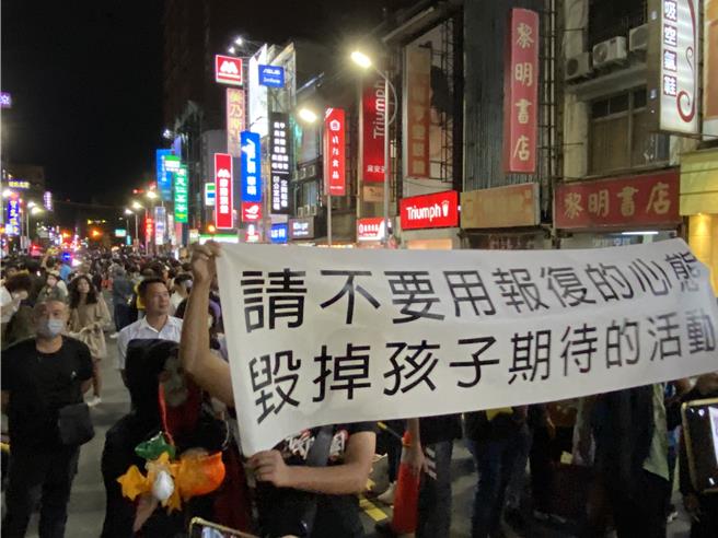 提款機的出現也引發部分遊行民眾的不滿，大遊行展開前幾分鐘，有民眾拉著「請不要用報復的心態，毀掉孩子期待的活動」白布條。（陳育賢攝）