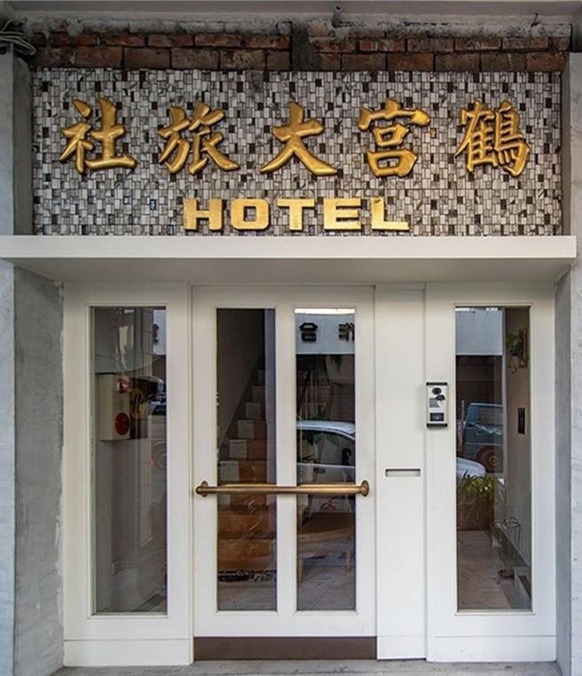 熱愛自助旅行的情侶Nato與Trista返鄉後，藉由青創貸款承租改造60多年歷史的老旅社「鶴宮寓」，門口懸掛著60年前「鶴宮大旅社」的金色招牌。（高市府青年局提供／洪浩軒高雄傳真）