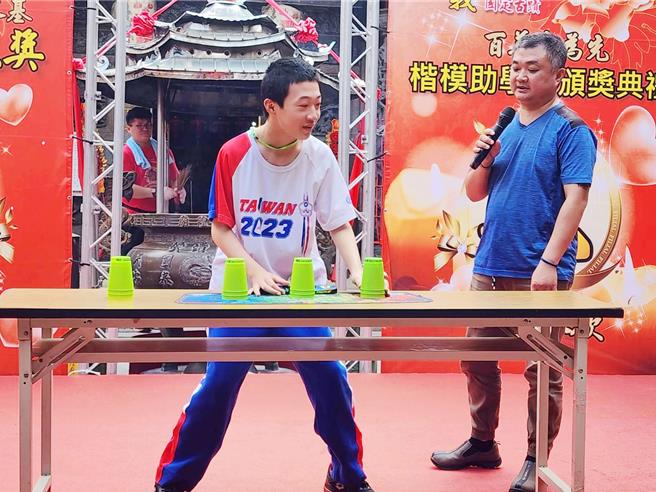 民生国中二年级特教生宋惟森29日在父亲宋建兴陪伴下，在台北展现迭杯技巧。（吕妍庭摄）