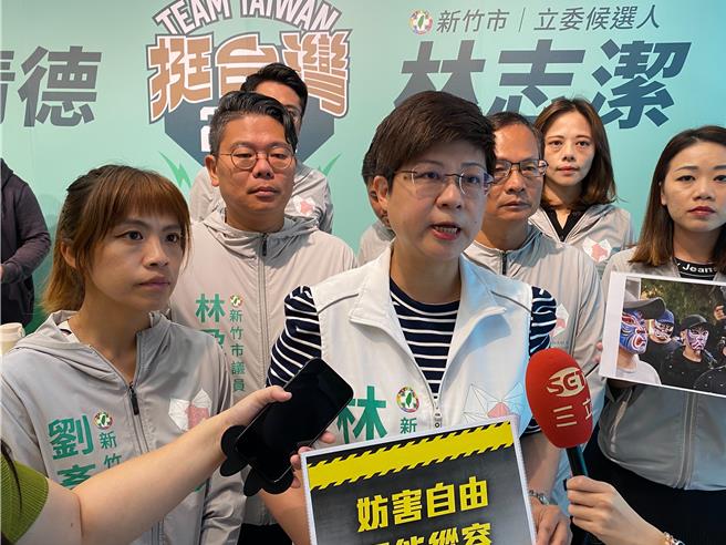 民進黨新竹市立委參選人林志潔（中）表示，畫臉譜的黑衣人包圍民眾打扮成的提款機，妨害他發放糖果給小朋友。還妨礙變裝者移動，這已經構成了刑法的強制罪。（陳育賢攝）