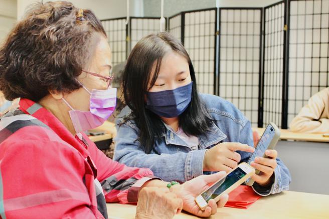 高龄及长期照护事业系学生耐心教导银髮长辈使用手机防诈骗电话设定（图片来源：辅英科大提供）