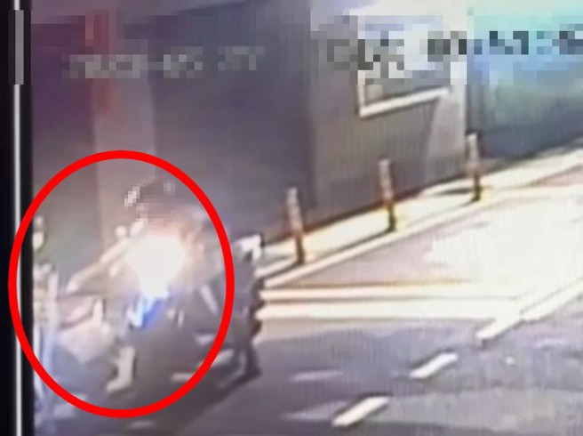 女子騎機車停等紅燈，遭後方男子尾隨噴灑不明液體。（警方提供）