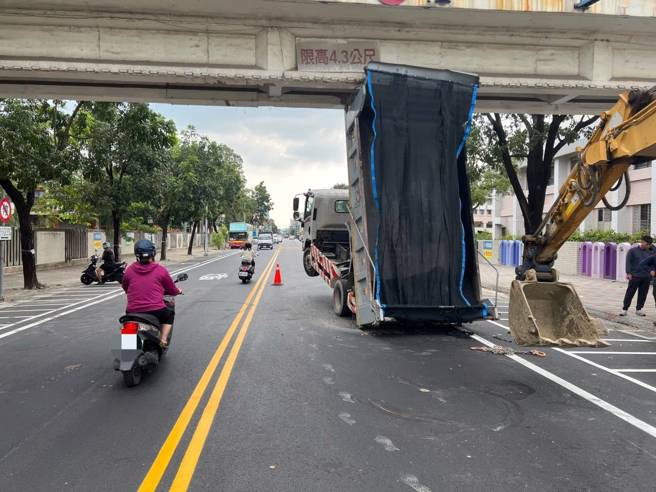 台南市归仁区国立新丰高中前，一辆大货车因车斗未收碰撞人行天桥的车祸，也让路人受到惊吓，而奇特的「翘孤轮」影像也让人瞠目结舌。（图／警方提供）