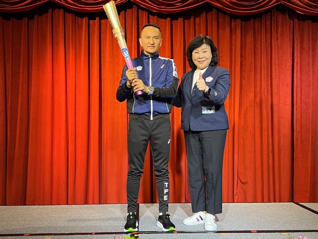 中华帕总会长穆闽珠（右）将杭州亚帕运圣火火把送给爱尔丽集团总裁常如山。（爱尔丽提供）