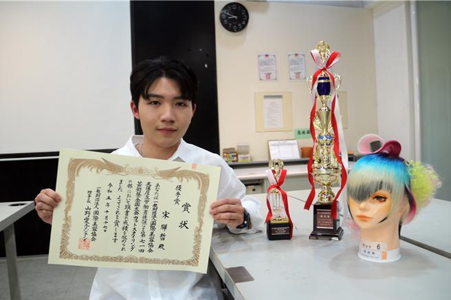 美髮系大四學生宋驊哲拿到剪髮造型組優秀獎及評審特別獎兩座獎盃。（陳淑娥攝）