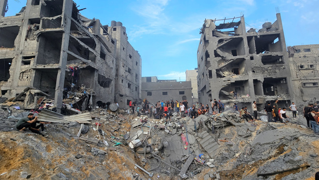 以色列31日空袭加萨北部贾巴利亚（Jabalia）难民营，在难民营炸出坑洞，建筑被夷为平地，其余建筑摇摇欲坠。（图／路透社）