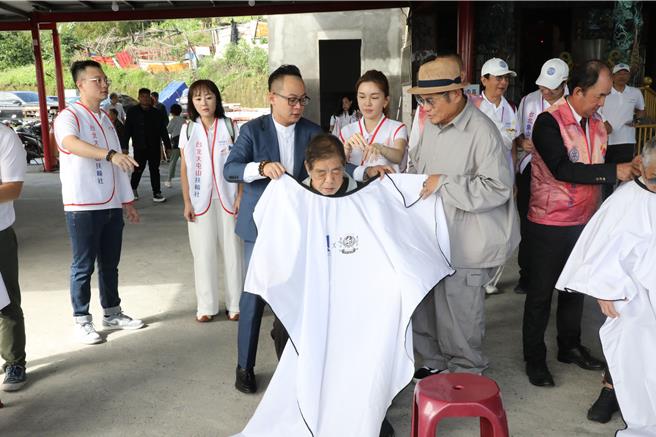 出身基隆的藝人許效舜與妻子同時也是大屯山扶輪社社長的陳愉為鼓勵基隆長輩走出家門，特別在中山區基隆地標附近的「三千宮」舉辦免費義剪。圖為議長童子偉（左三）及許效舜（右三）替長輩為上理髮圍裙之情形。（童子瑋辦公室提供／徐佑昇基隆傳真）