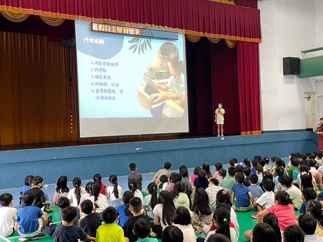 全校自主学习分享会上，学生于台上分享环岛经验，透过全程自行规划及父母的支持，学习到规划及应变能力(图/台北市教育局提供)