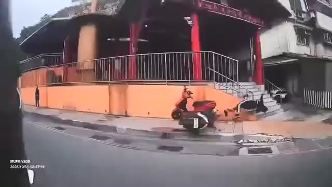 机车自摔后，人车飞起，撞到庙宇外的栏杆。（翻摄爆料公社二社）