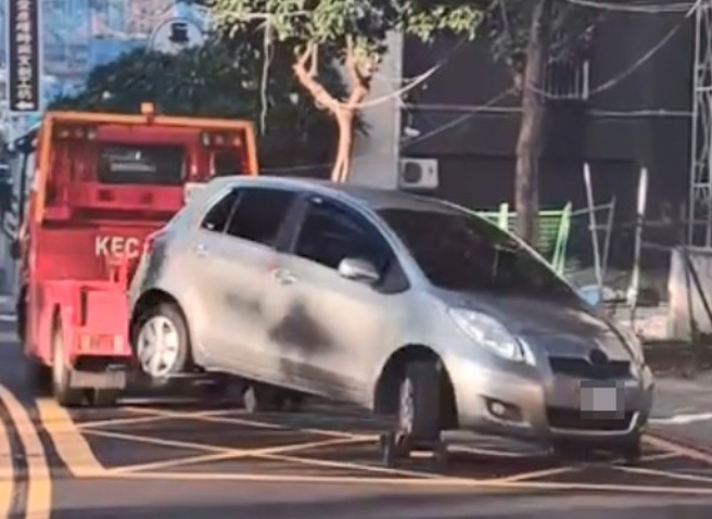 违规轿车方向盘打死，拖吊车拖吊行驶摇摇晃晃。（翻摄爆料公社二社）