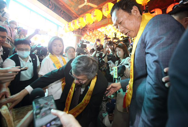 台北市葫蘆寺2日舉行「觀音佛祖出家紀念日 北宮媽祖起駕大典」儀式，國民黨總統參選人侯友宜、民眾黨總統參選人柯文哲（左）及鴻海創辦人郭台銘（右）同框出席，三人光是座位就變動8次，最後柯文哲幫郭台銘親自調整座位。（張鎧乙攝）
