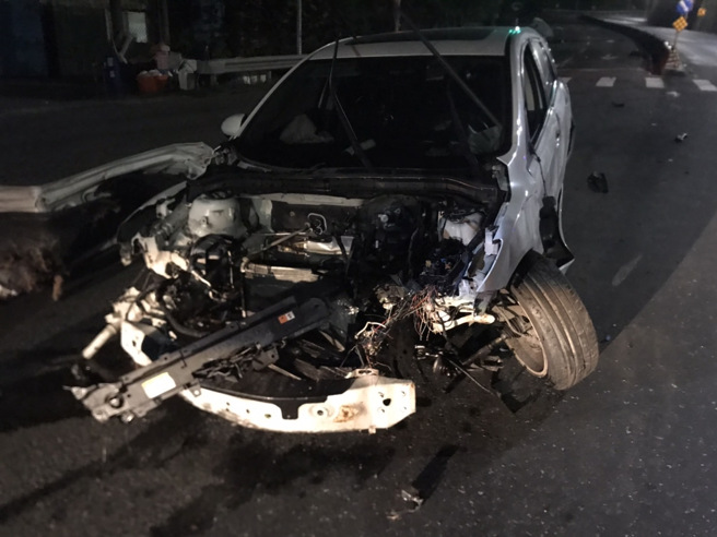 新北市淡水區淡金路與興仁路口29日凌晨3時30分許，發生一起自撞車禍，1輛自小客車疑車速過快失控自撞路旁商家石敢當及電桿。（圖／警方提供）