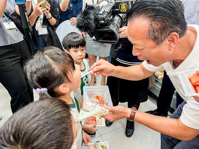 翁章梁还与小朋友亲切互动，弯腰将木瓜喂给小朋友吃，美味木瓜让学童直呼想再吃一块。（嘉义县政府提供∕吕妍庭嘉义传真）