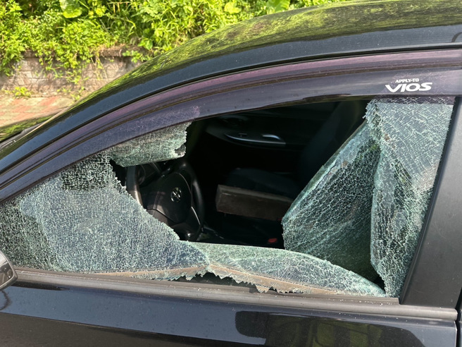 張男與妻子在路邊爭吵，事後撒出鈔票，就在老婆撿拾鈔票之際，張男竟男路邊石頭，砸破停車格車子的車窗。（圖／警方提供）