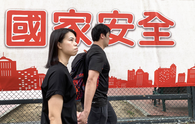 一名留学日本的香港女学生被香港国安员警指控发布网文宣扬「港独」，在返回香港后被法院判处入狱2个月。图为香港民眾行经宣传国家安全标语牌。（图／中新社）