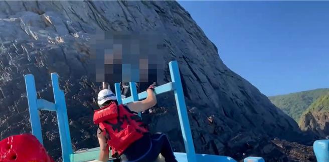 2名釣客今天受困南方澳玻璃海灘，消防、海巡人員搭乘舢舨船接近，順利救出受困釣客。（宜蘭縣消防局提供／李忠一宜蘭傳真）