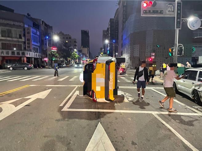 七賢二路上一輛計程車疑似因精神不濟，自撞路邊2輛汽車後側翻於路中間，遭警救出所幸僅受輕傷。（警方提供／任義宇高雄傳真）