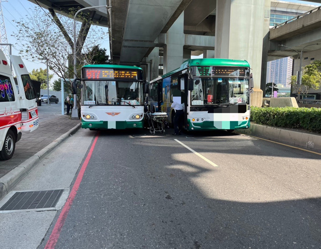 女骑士的机车卡在2辆公车之间，救护人员到达将女骑士送医。（警方提供）