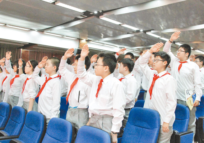 紅色領巾是大陸少先隊員的服飾特徵。（圖 / 新華社）