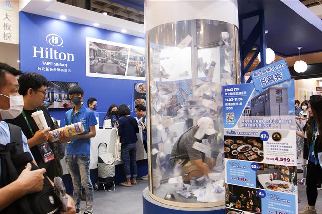 業者搬出滿額體驗人體鈔票機活動，現場消費單筆滿1萬元就能體驗抓鈔機，有機會抓到免費住宿券、500元抵用券等好禮。(台北新板希爾頓酒店提供)