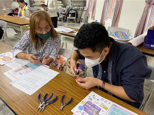 苏荣世(右)亲手编织成一条华丽的饰品，妈妈(左)也在一旁学习。（移民署提供）