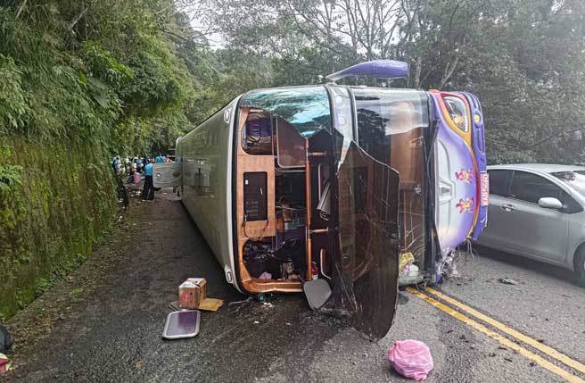 鸠之泽温泉附近山路1辆游览车忽然侧翻，车头玻璃大面剥落。（翻摄画面）