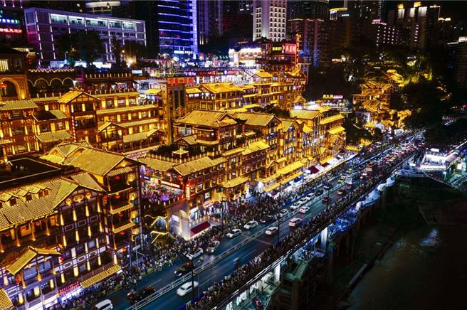 重庆洪崖洞位于嘉陵江边千厮门大桥旁，仿巴渝传统建筑吊脚楼依山而建。每当夜幕降临，洪崖洞依山临水的吊脚楼灯火辉煌，美轮美奂、游人如织。诸如小熊集市这样的新兴网红夜市也日益生机勃勃，丰富着重庆的夏夜。（新华社）