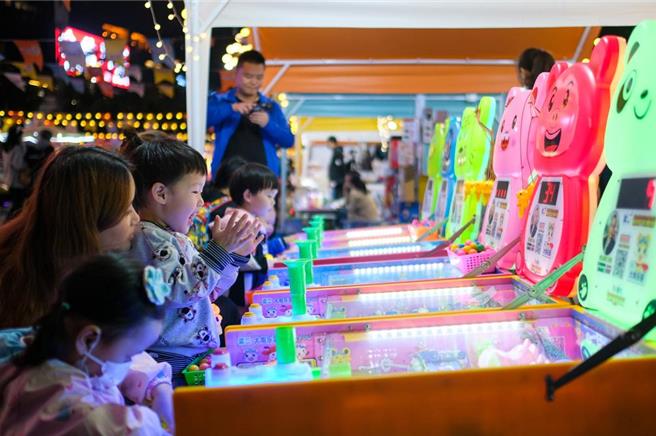 重庆市南岸区南滨路烟雨公园，日前举办「彩虹集市」。集市上特色小吃、饮品、手工艺品等摊位依次排开，既有浓浓的烟火气，又散发着十足的时尚范儿，成为秋日山城夜晚一道亮丽的风景线，为城市夜经济增添了不少活力。（中新社）